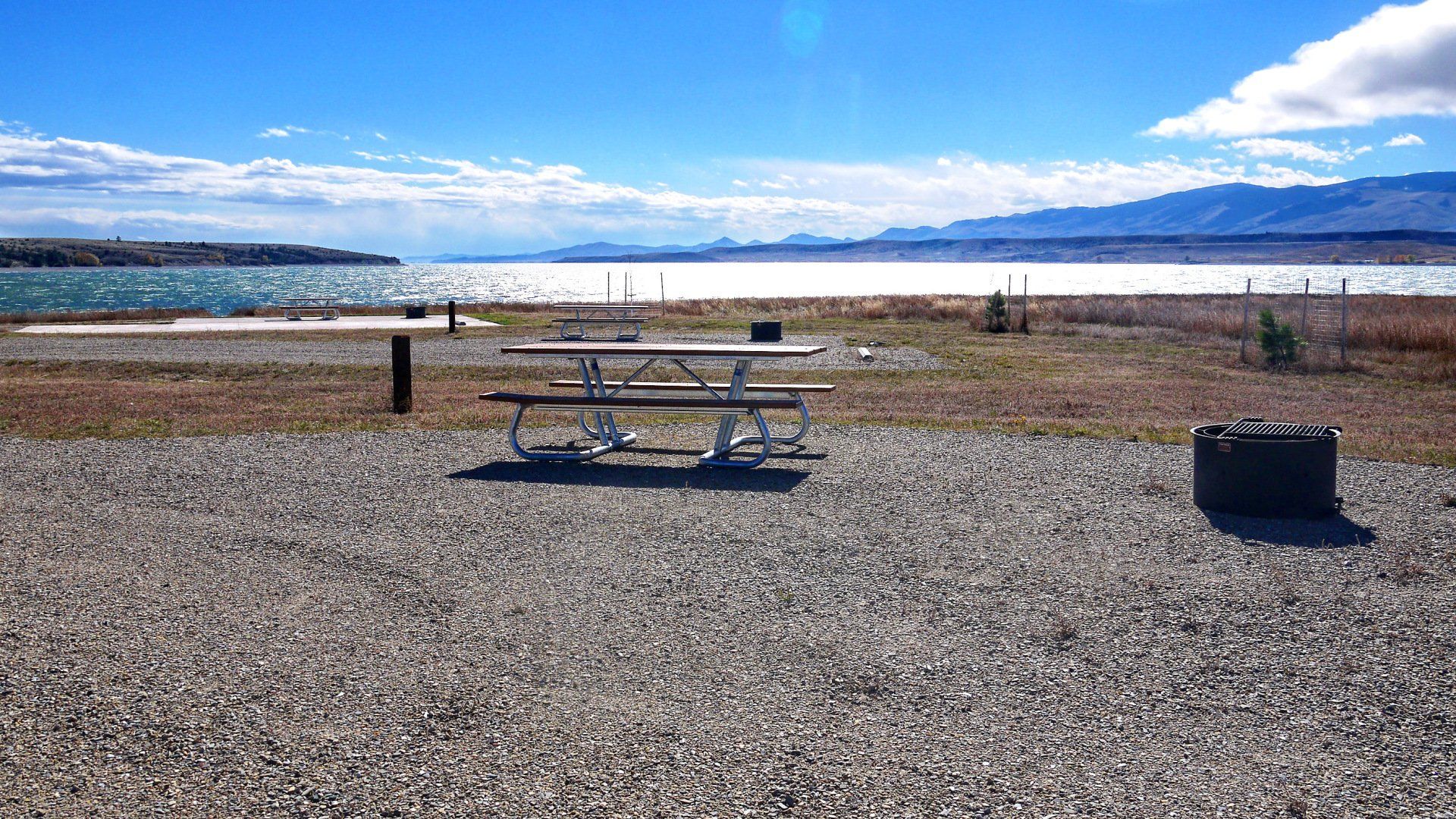 A picnic table with a lake in the background