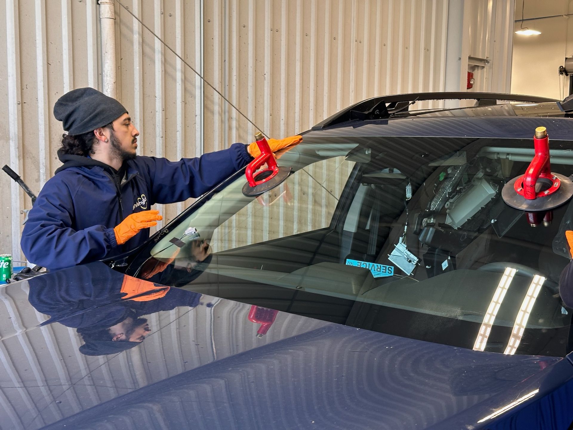 A man is installing a windshield on a car.