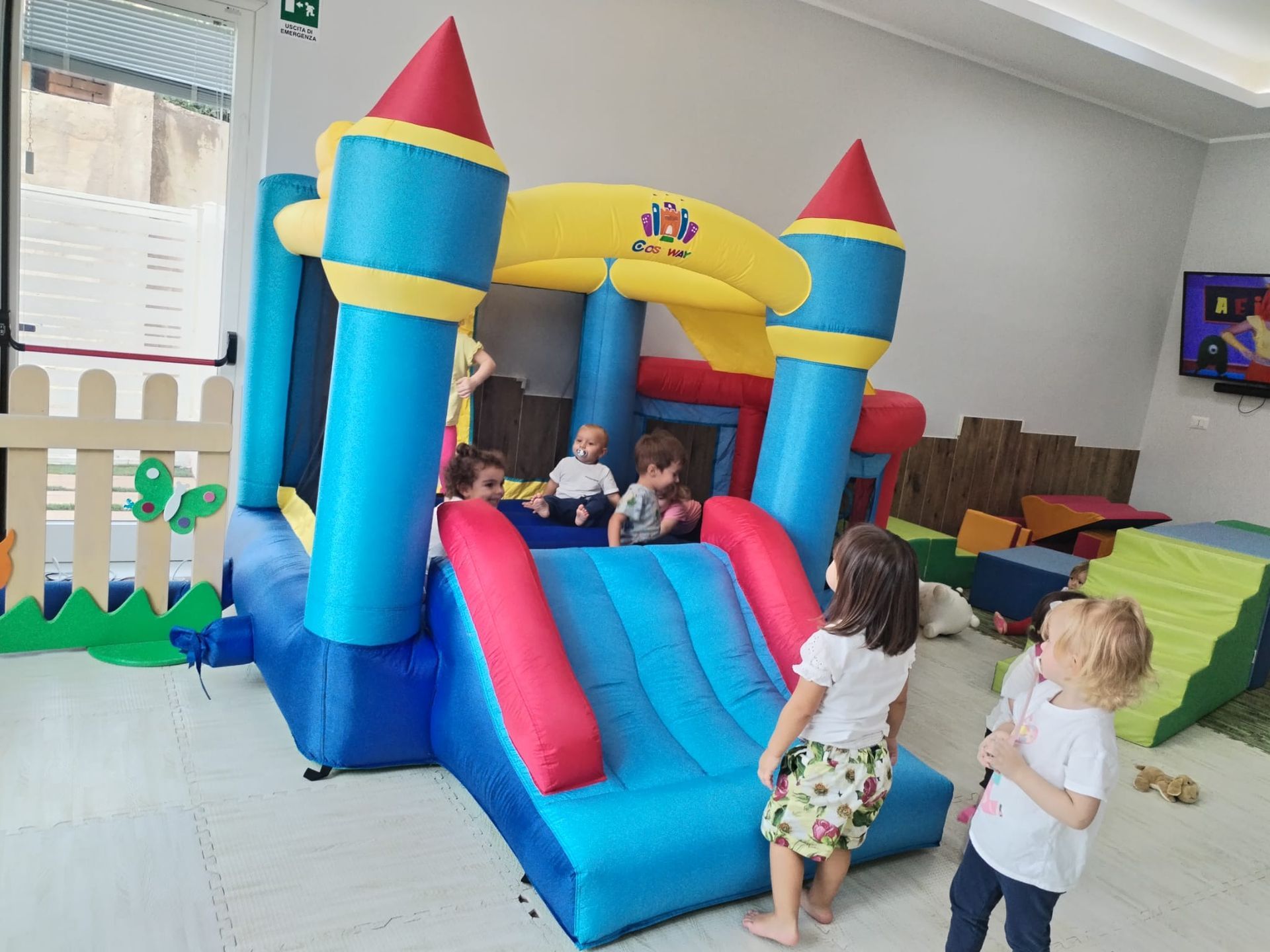 Un gruppo di bambini sta giocando in un castello gonfiabile.