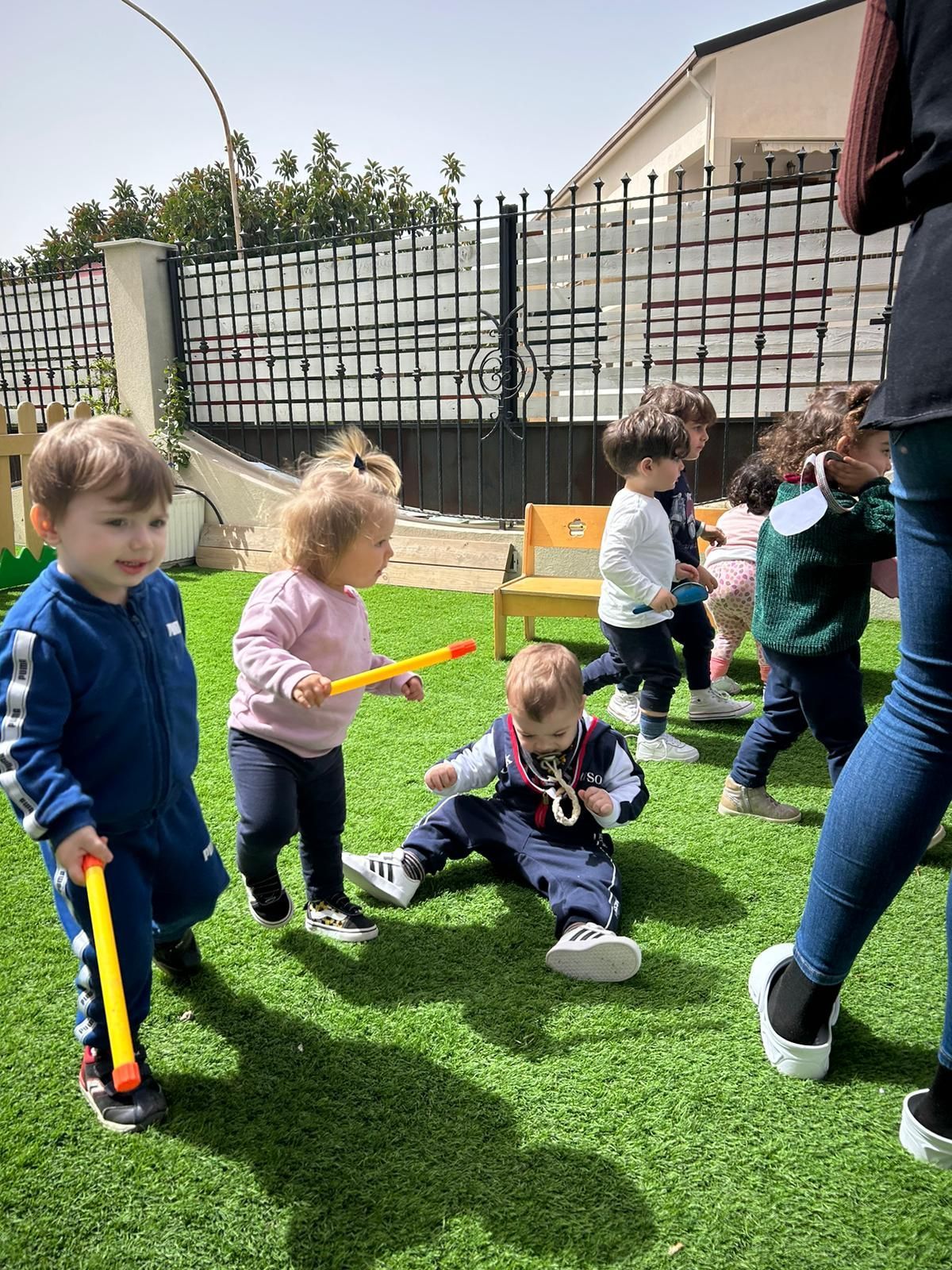 Un gruppo di bambini piccoli sta giocando in un rigoglioso campo verde.