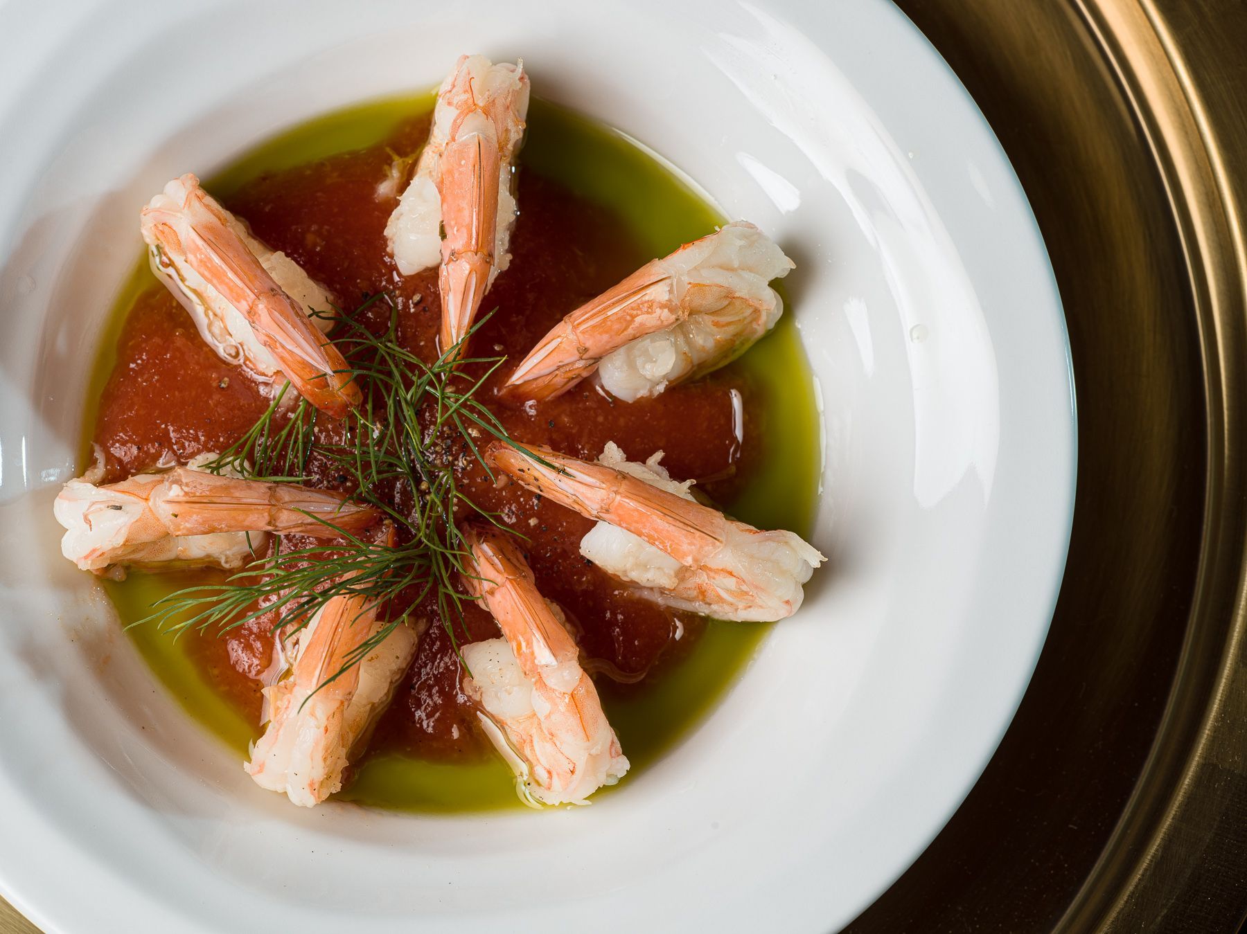 A white plate topped with shrimp and tomato sauce