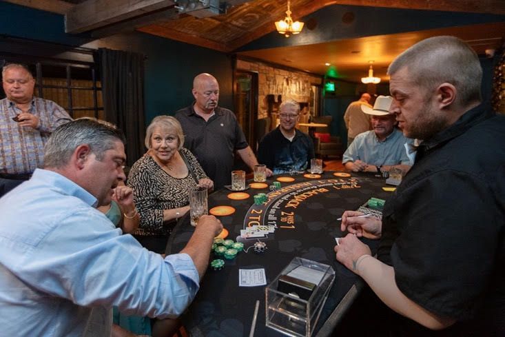A group of people are playing a game of blackjack at a table.