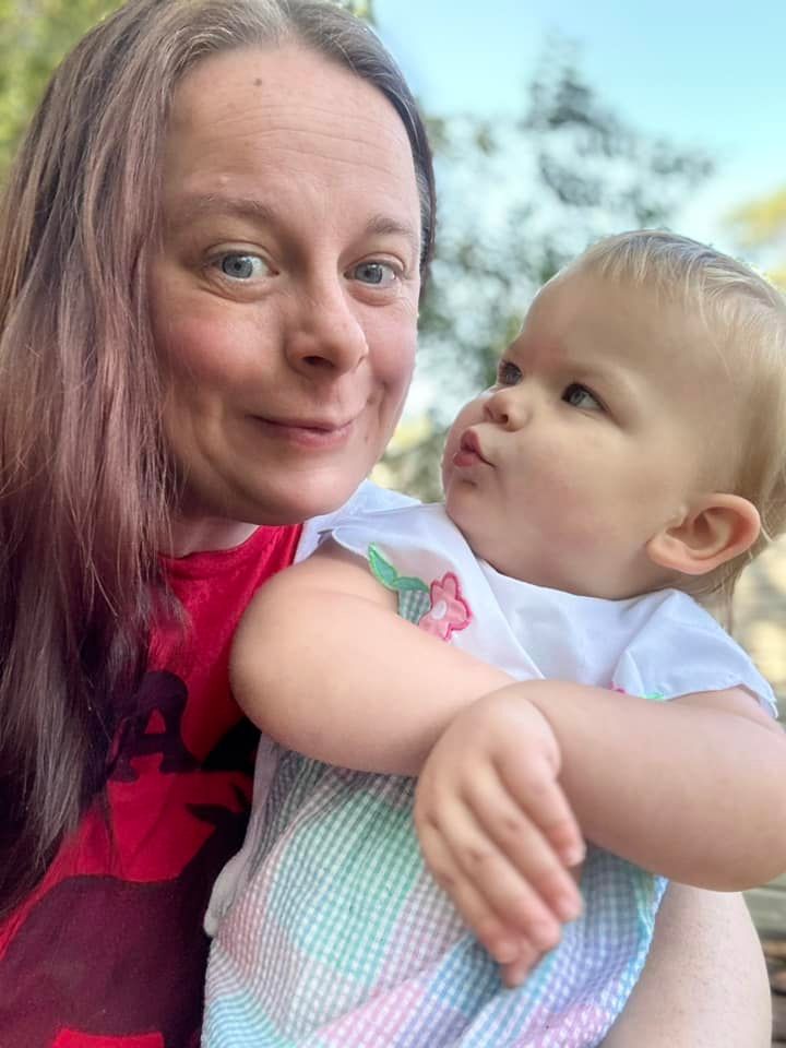 A woman is holding a baby in her arms.