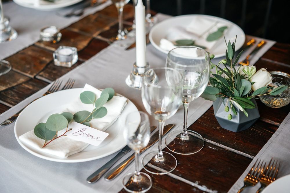 A Table Set for a Wedding Reception With Plates , Glasses , Candles and Flowers — Tuncurry Washerteria In Diamond Beach, NSW
