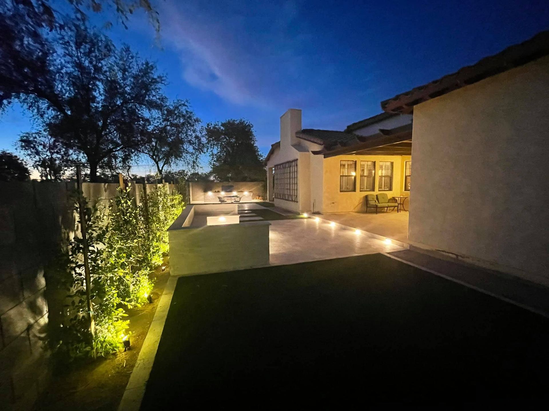 A house with a pool in the backyard at night