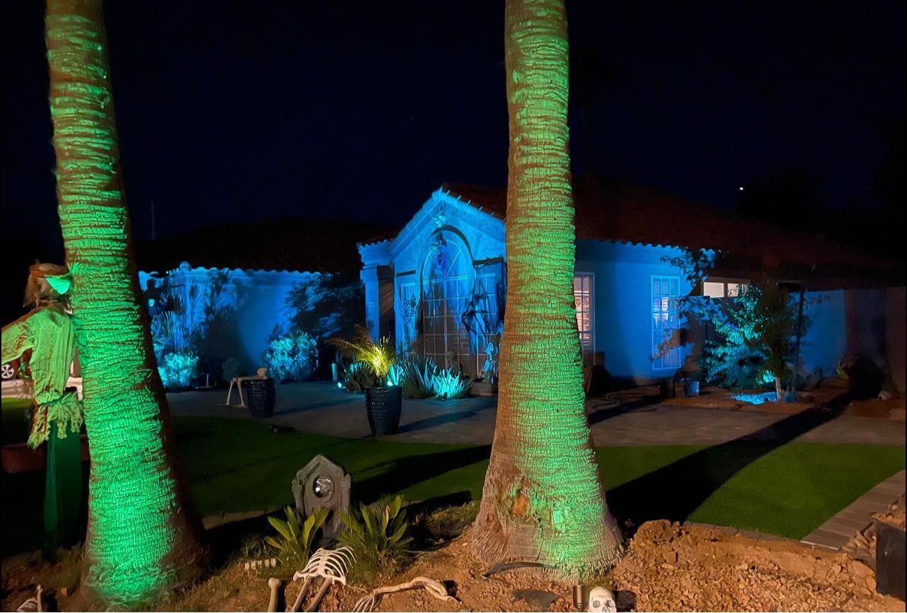A house is lit up with green lights at night.