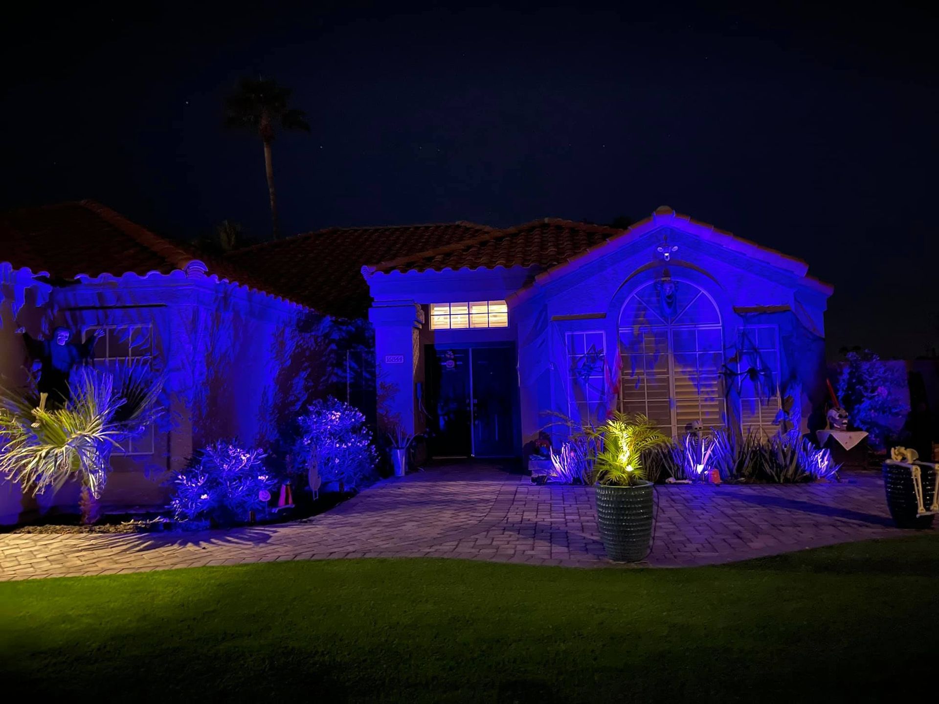 A house is lit up with blue lights at night.