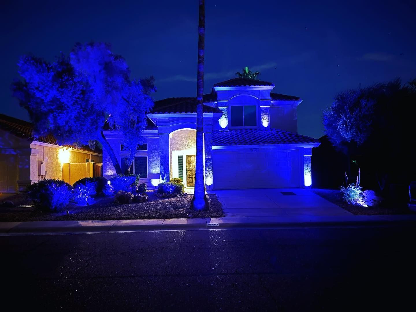 A house is lit up with blue lights at night.