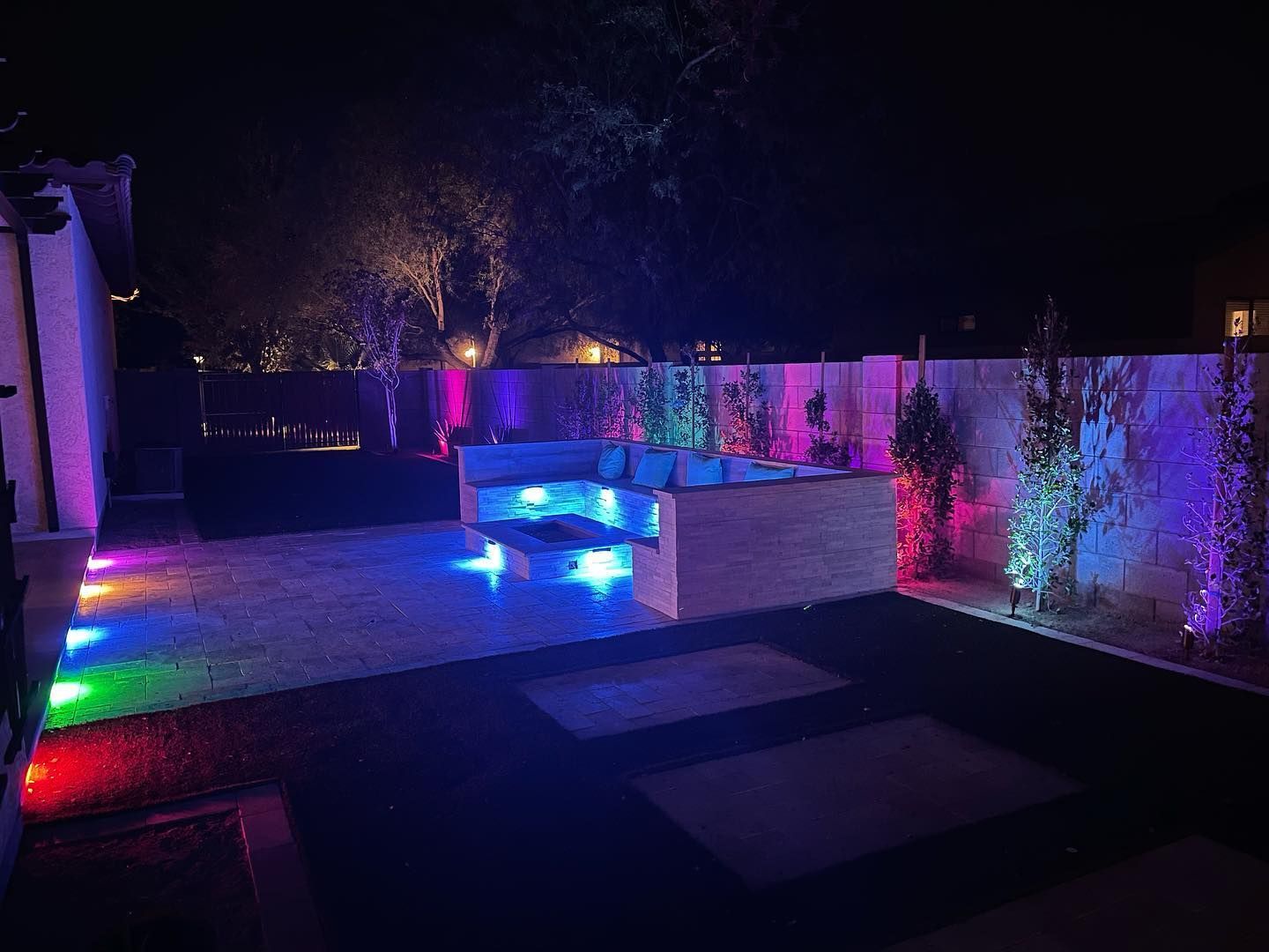 A backyard at night with a lot of lights on it.