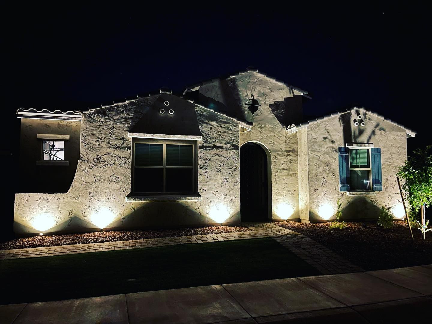 The front of a house is lit up at night.