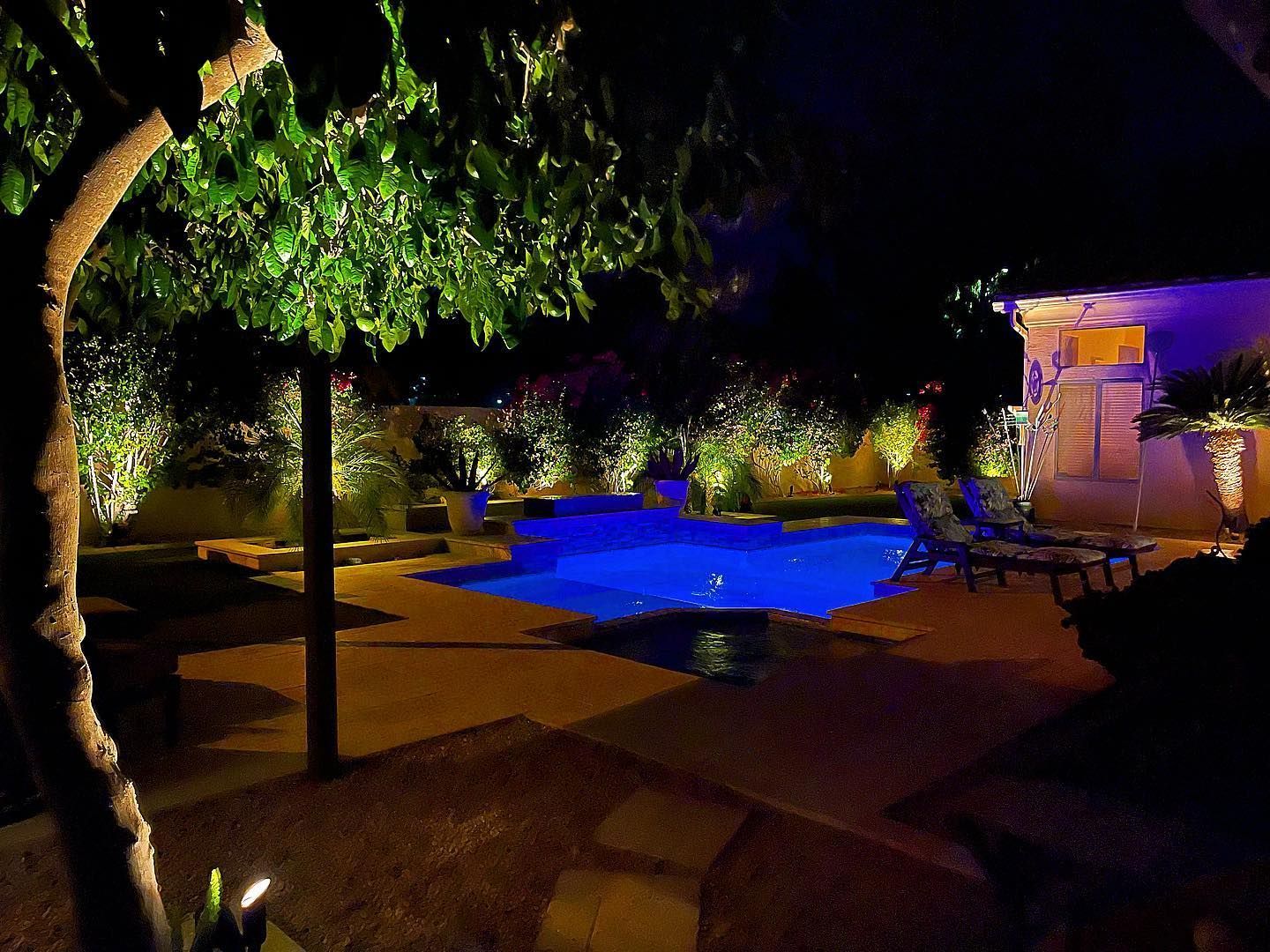 A large swimming pool is lit up at night