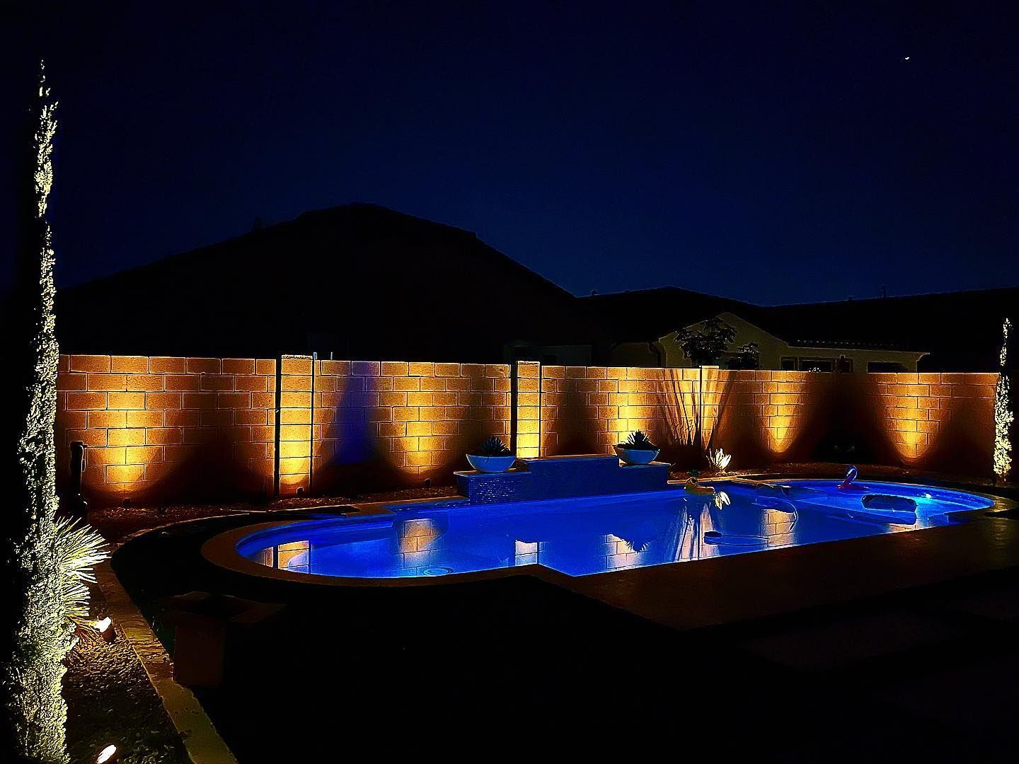A large swimming pool is lit up at night