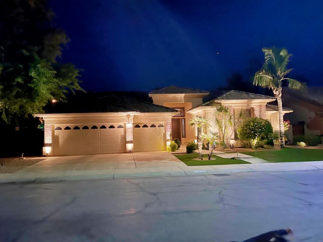 A house with two garage doors is lit up at night.