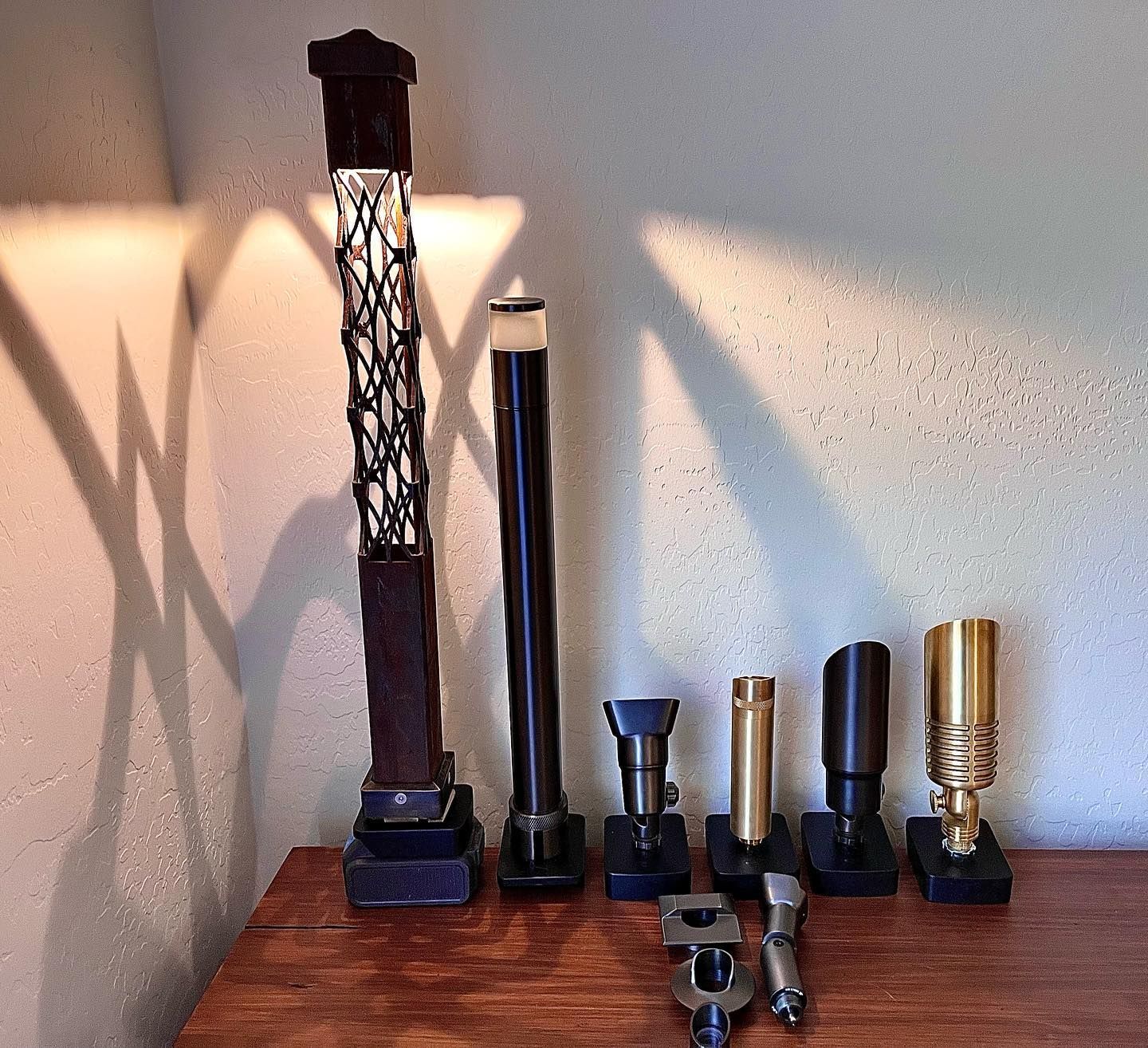 A group of candle holders are lined up on a wooden table