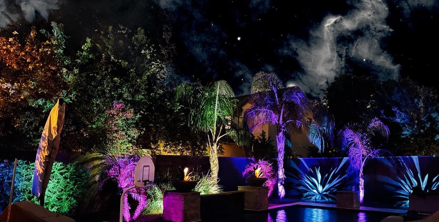 A swimming pool is lit up with colorful lights at night.