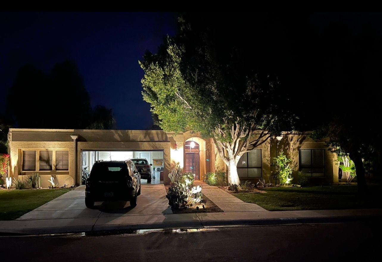 A car is parked in front of a house at night.