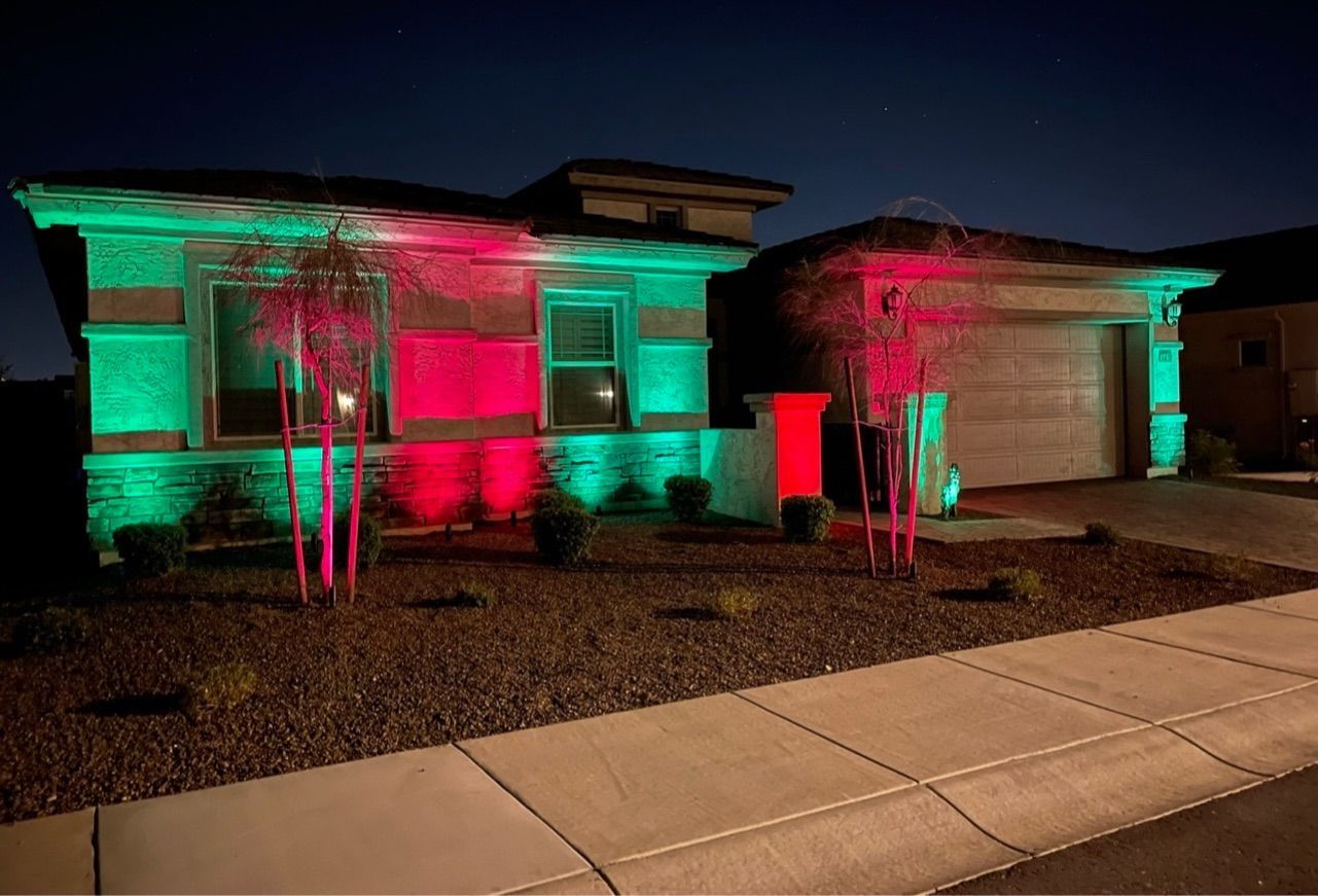 A house is lit up with green and red lights at night.