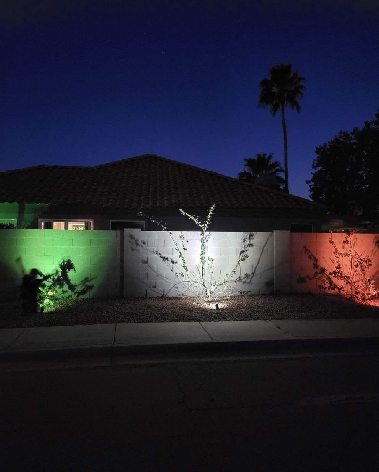 A house is lit up with green and orange lights