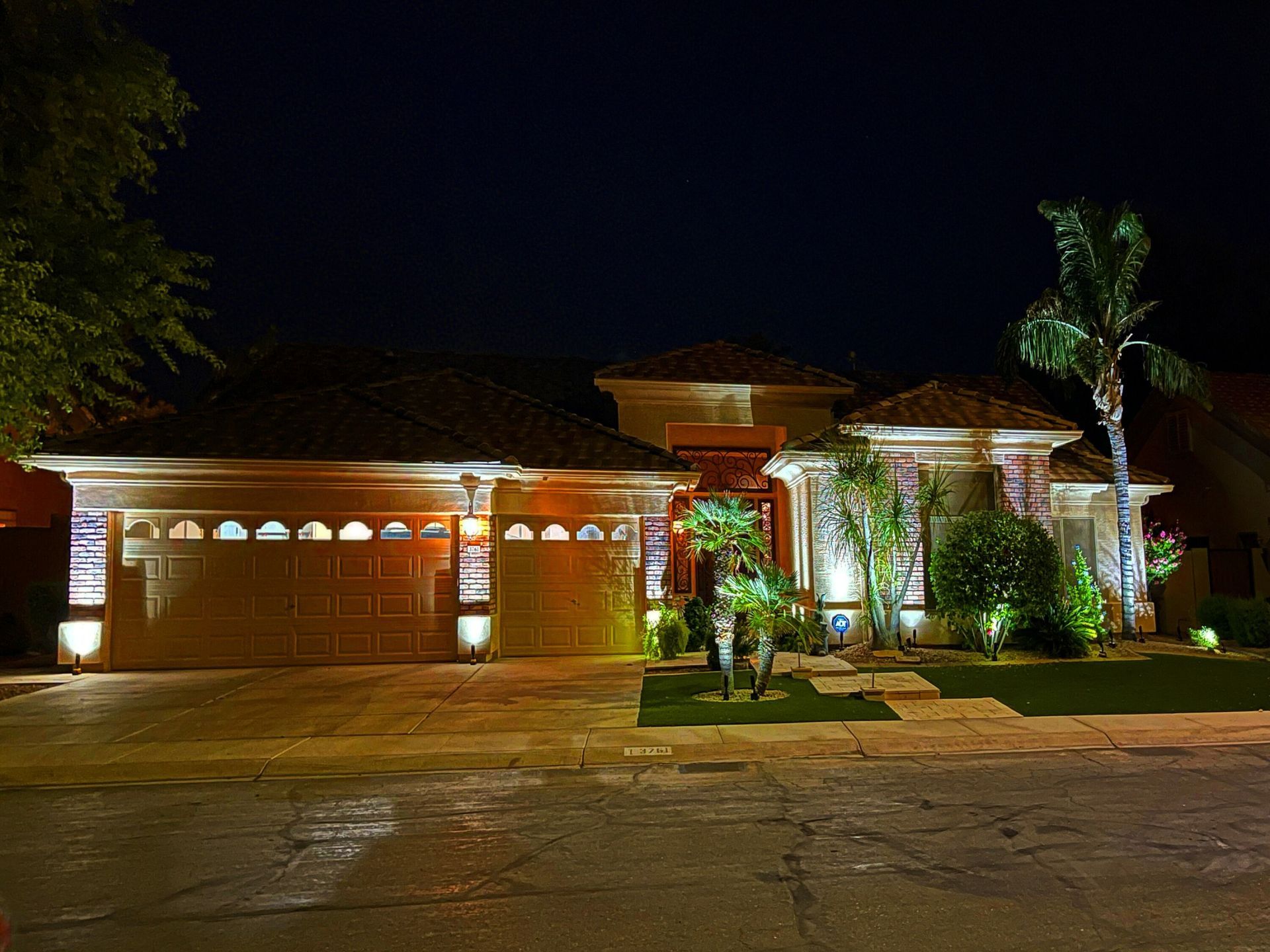 The front of a house is lit up at night
