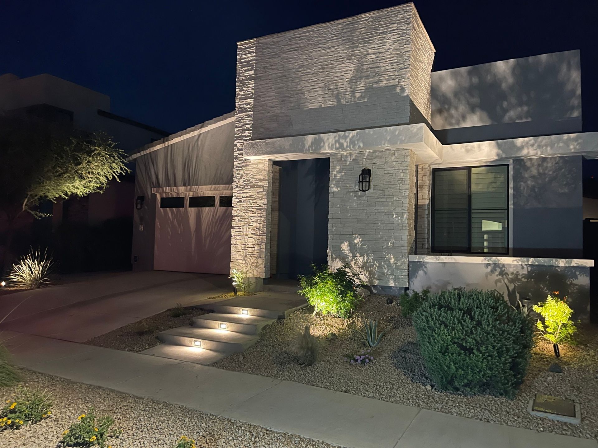 The front of a house is lit up at night.