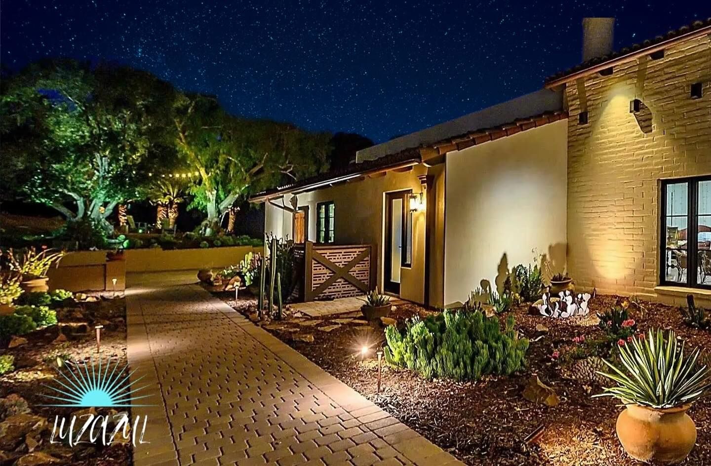 A house with a walkway leading to it at night