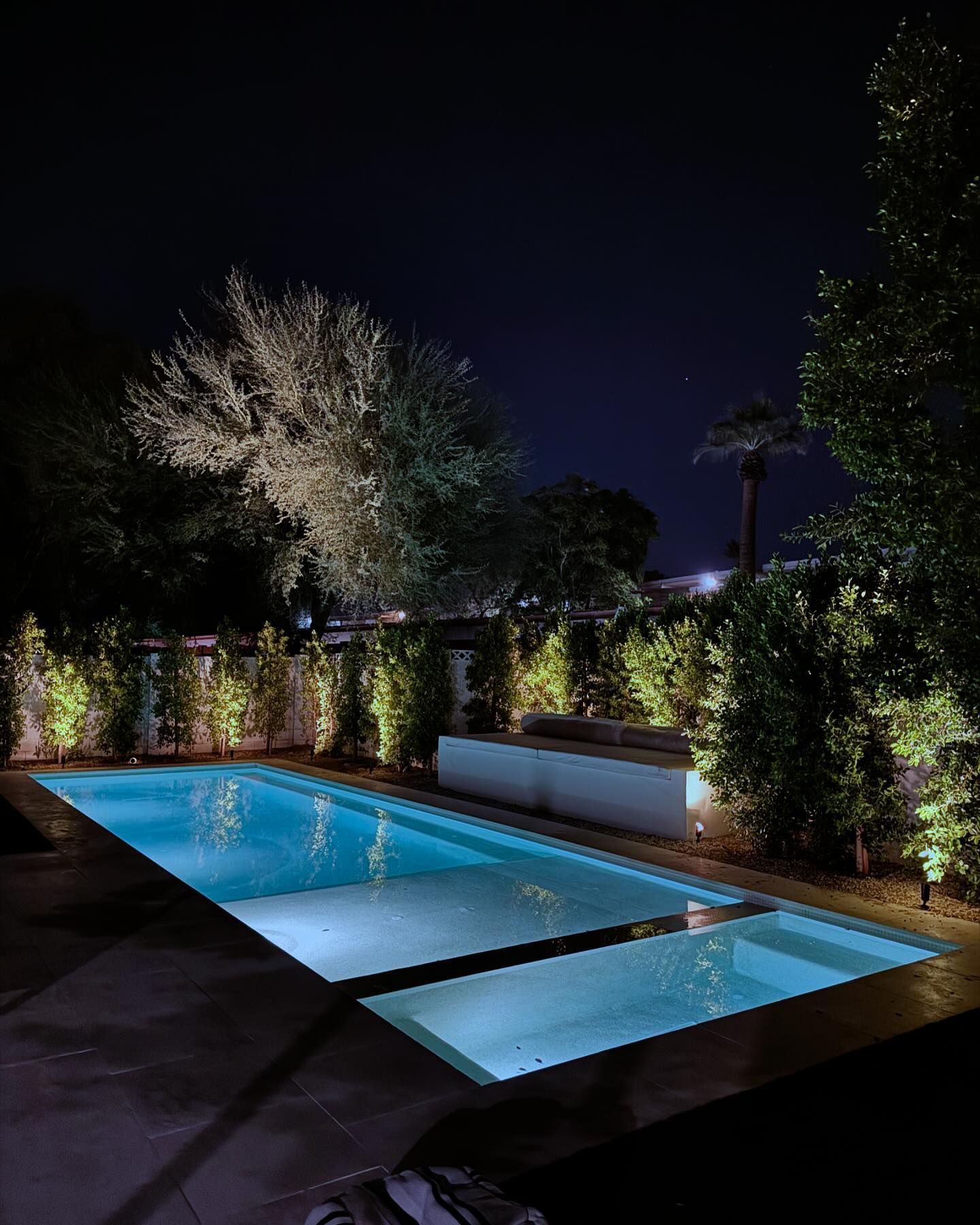 A large swimming pool is lit up at night