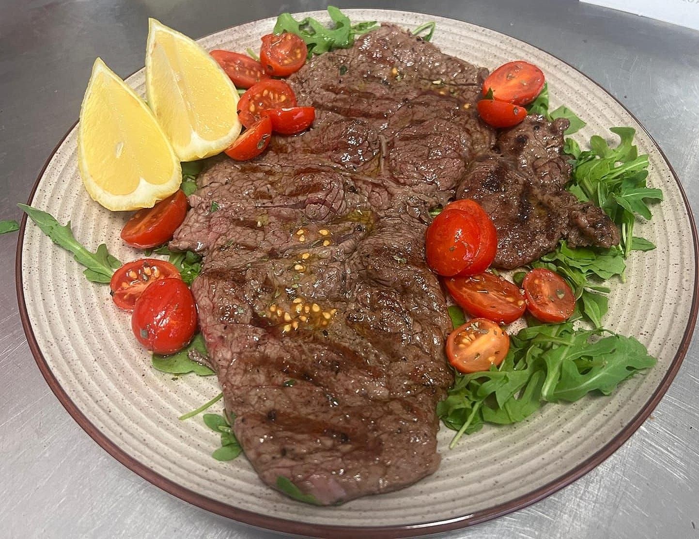 piatto bistecca di carne con pomodorini e rucola