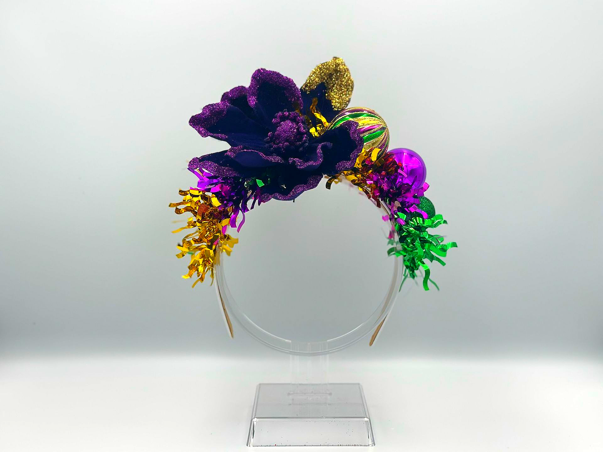 Mardi Gras headband with purple, gold, and green glitter flowers and tinsel on a silver band.
