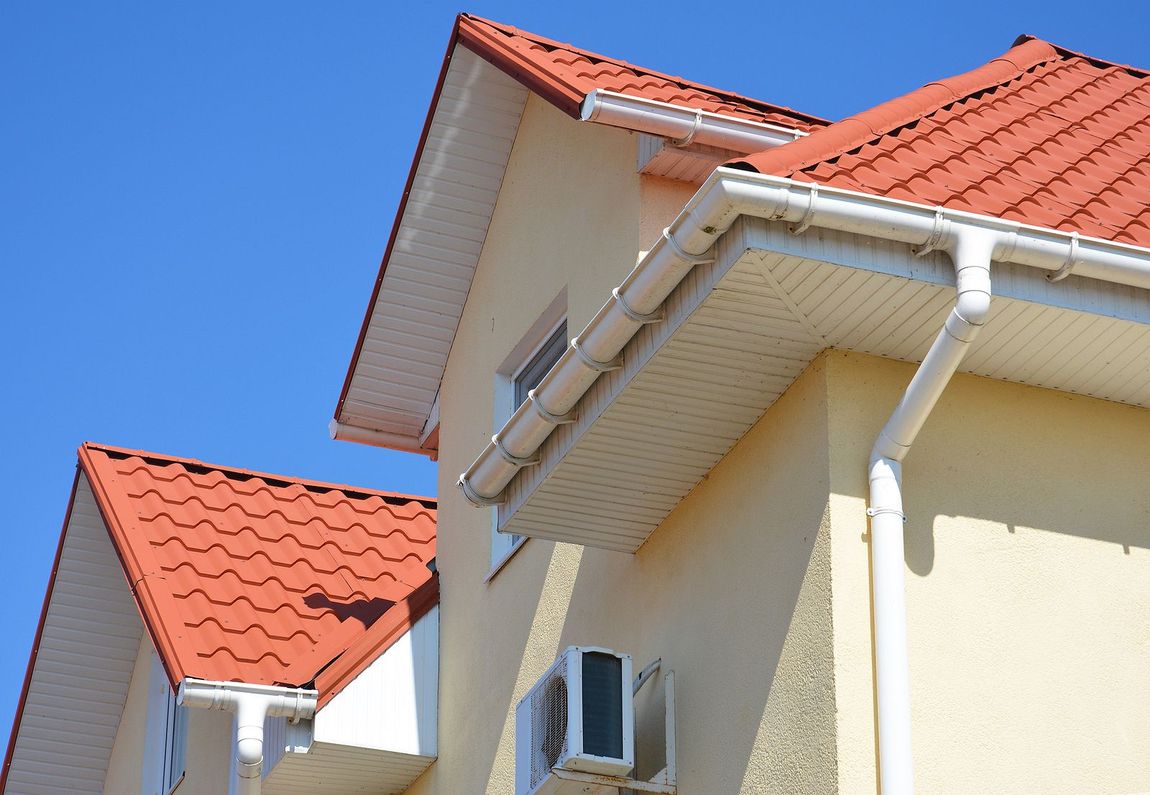 A house with a red roof and white gutters