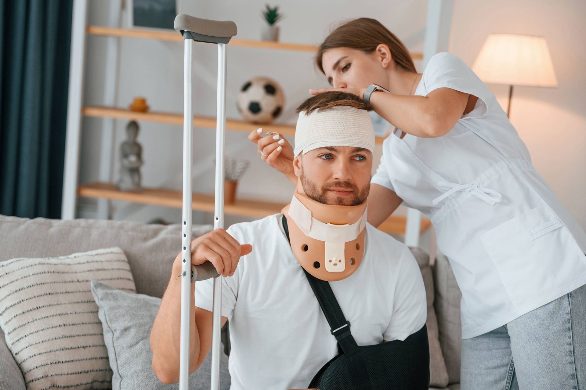 a woman is helping a man with a neck brace and crutches