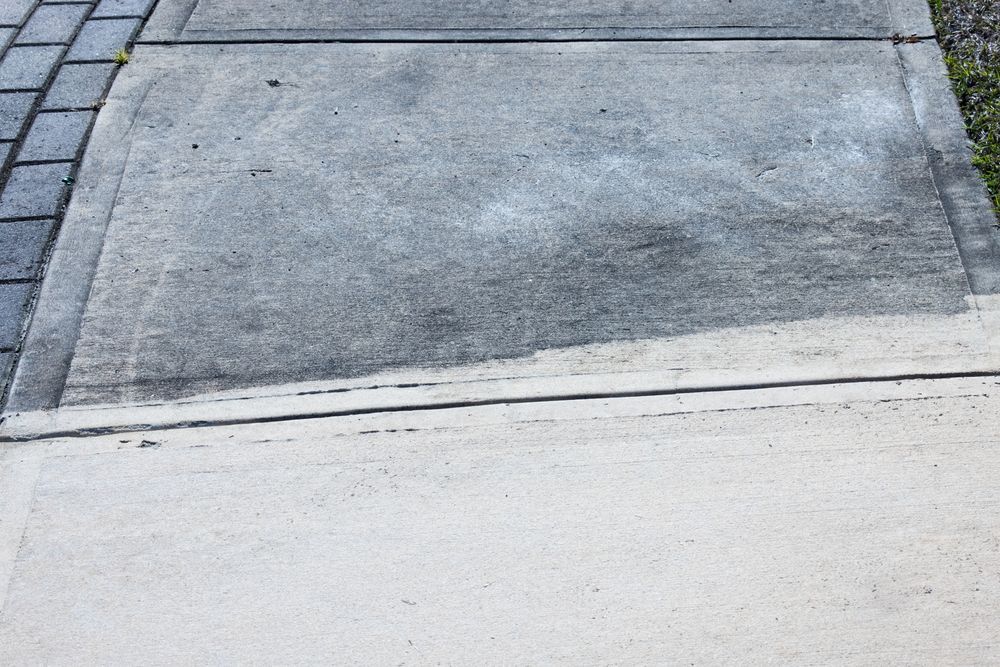 A person is using a pressure washer to clean a concrete floor.