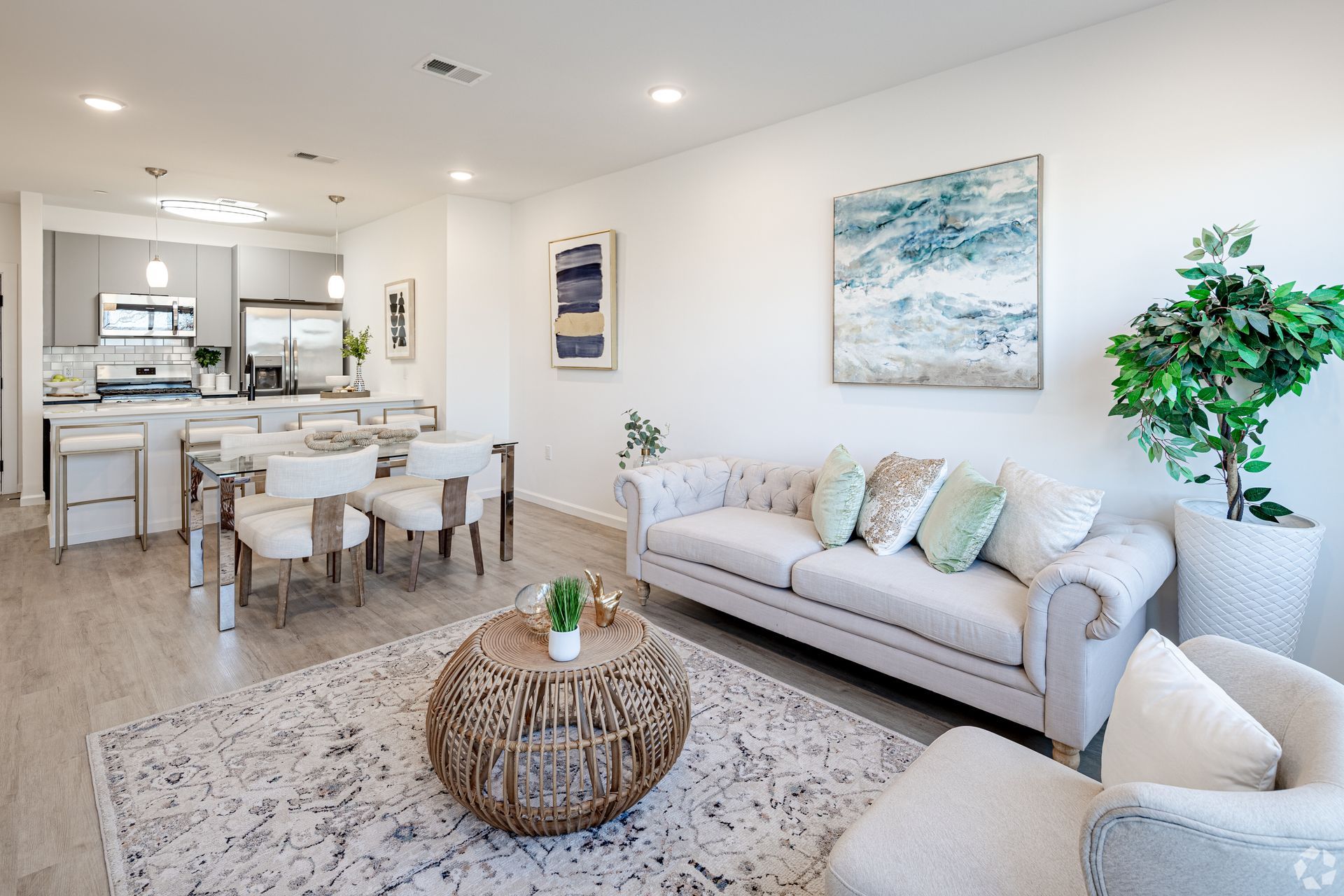 A living room with a couch , chair , coffee table and painting on the wall.- The Unity