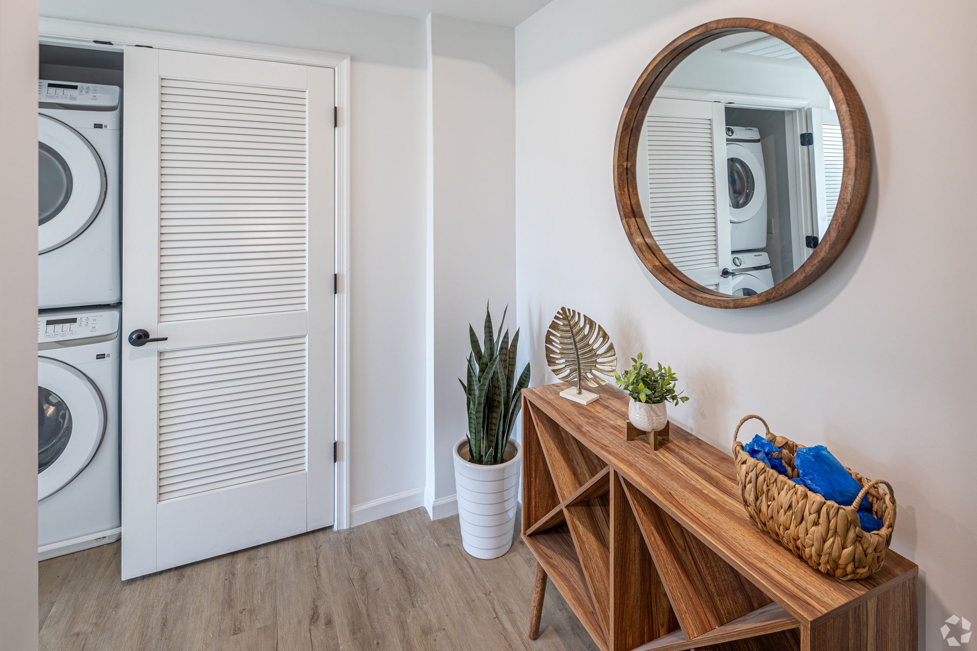 A laundry room with a washer and dryer and a mirror.- The Unity