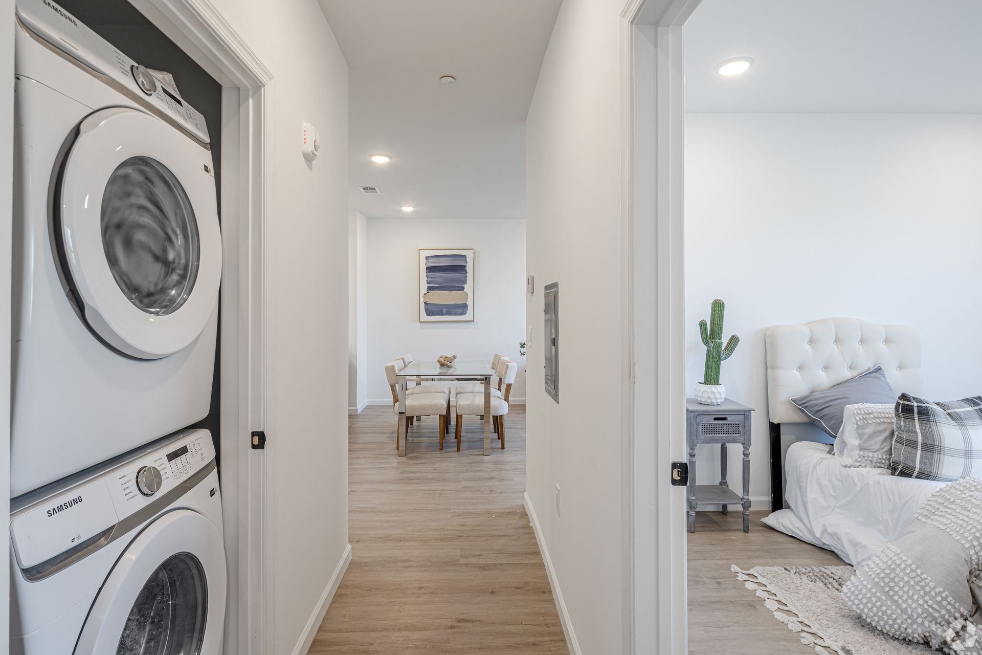 A hallway with a washer and dryer stacked on top of each other.- The Unity