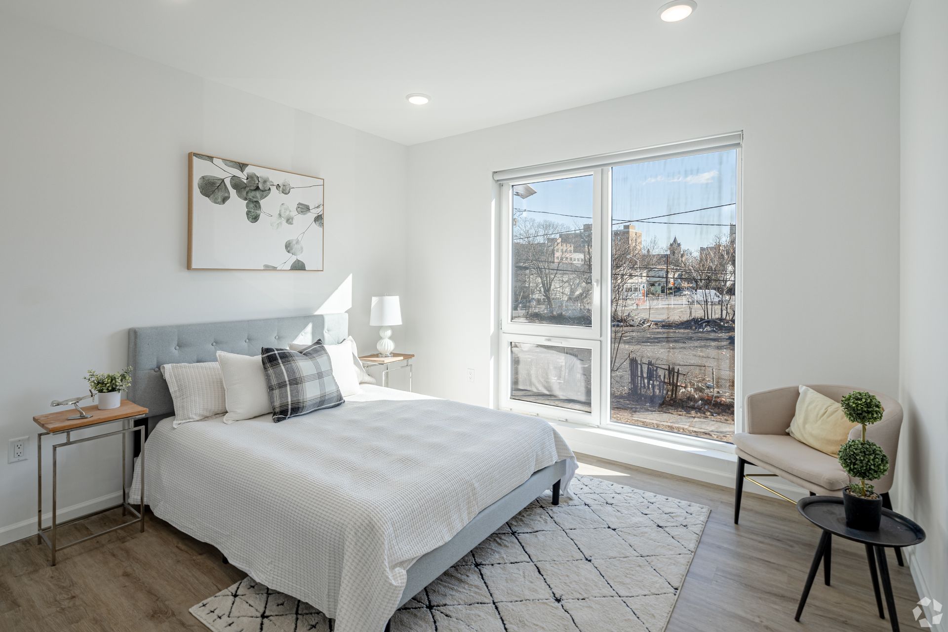 A bedroom with a large bed and a large window.- The Unity