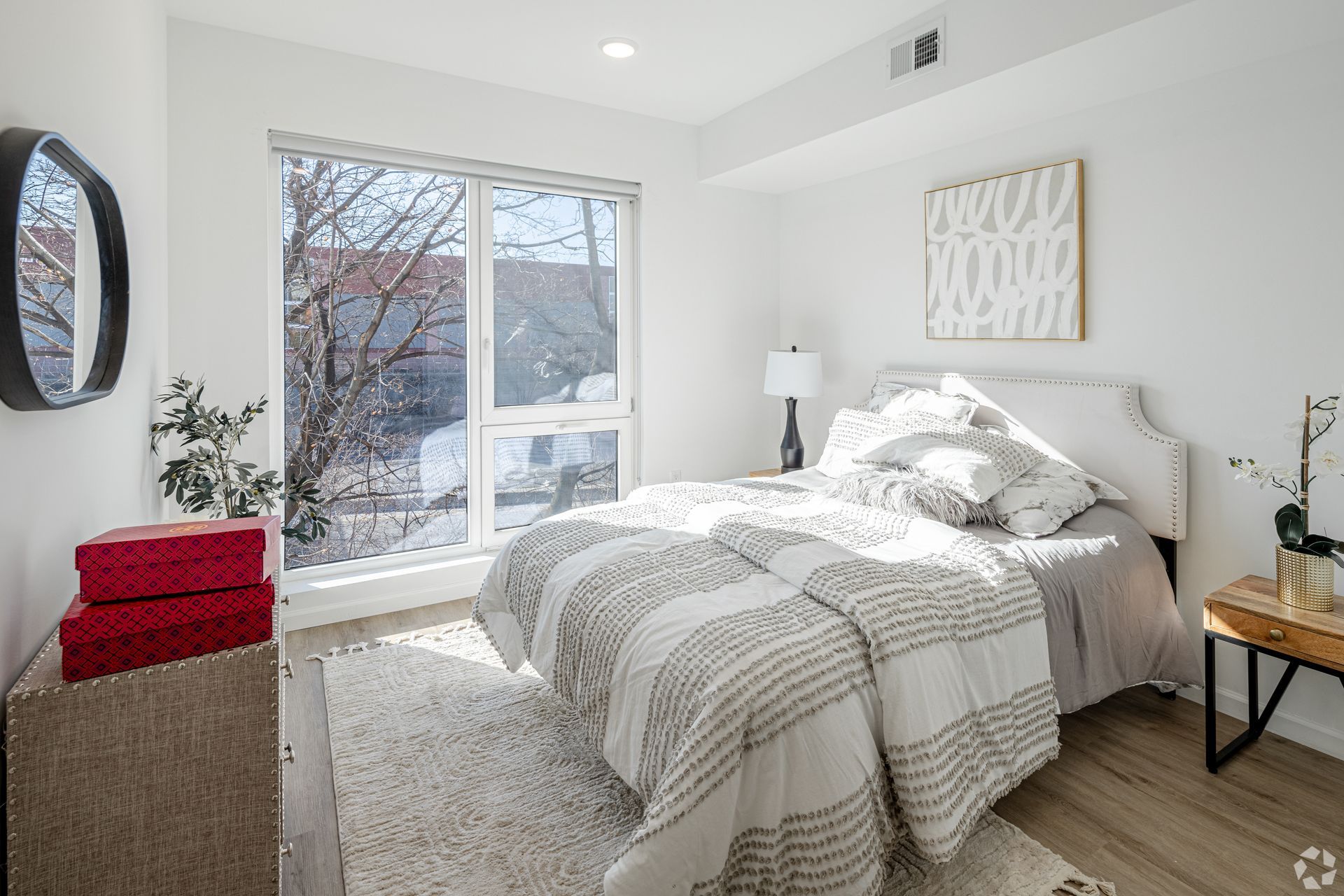 A bedroom with a large bed and a large window.- The Unity