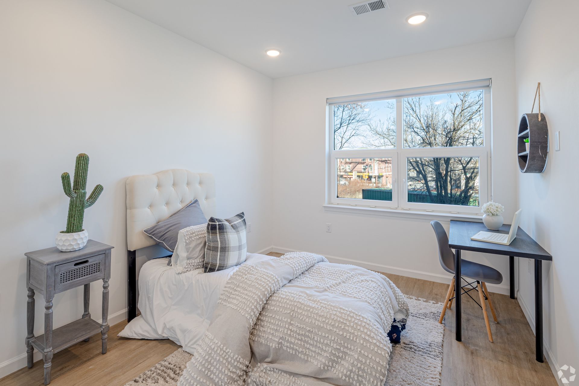 A bedroom with a bed , desk , nightstand and window.- The Unity