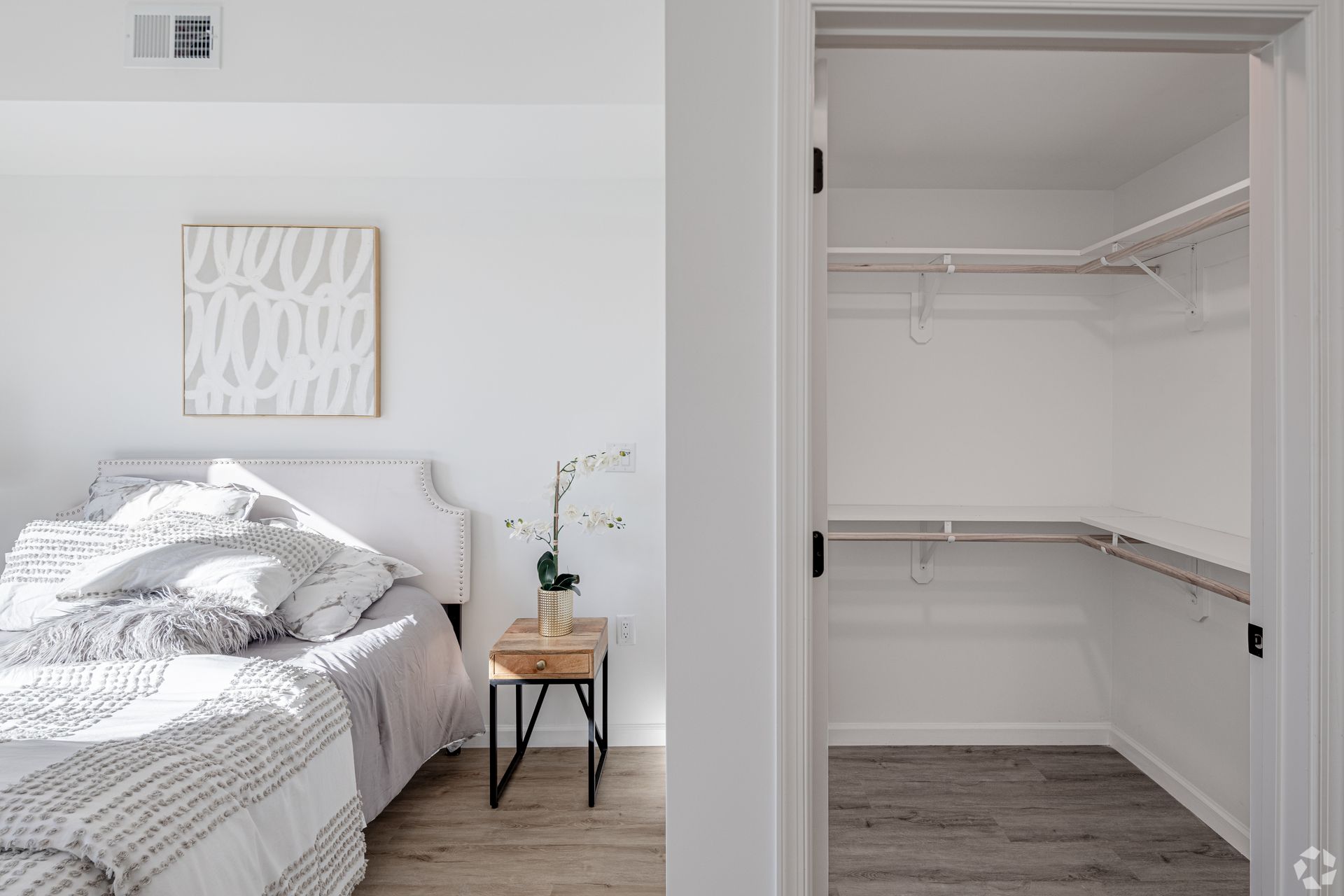 A bedroom with a bed and a walk in closet.- The Unity