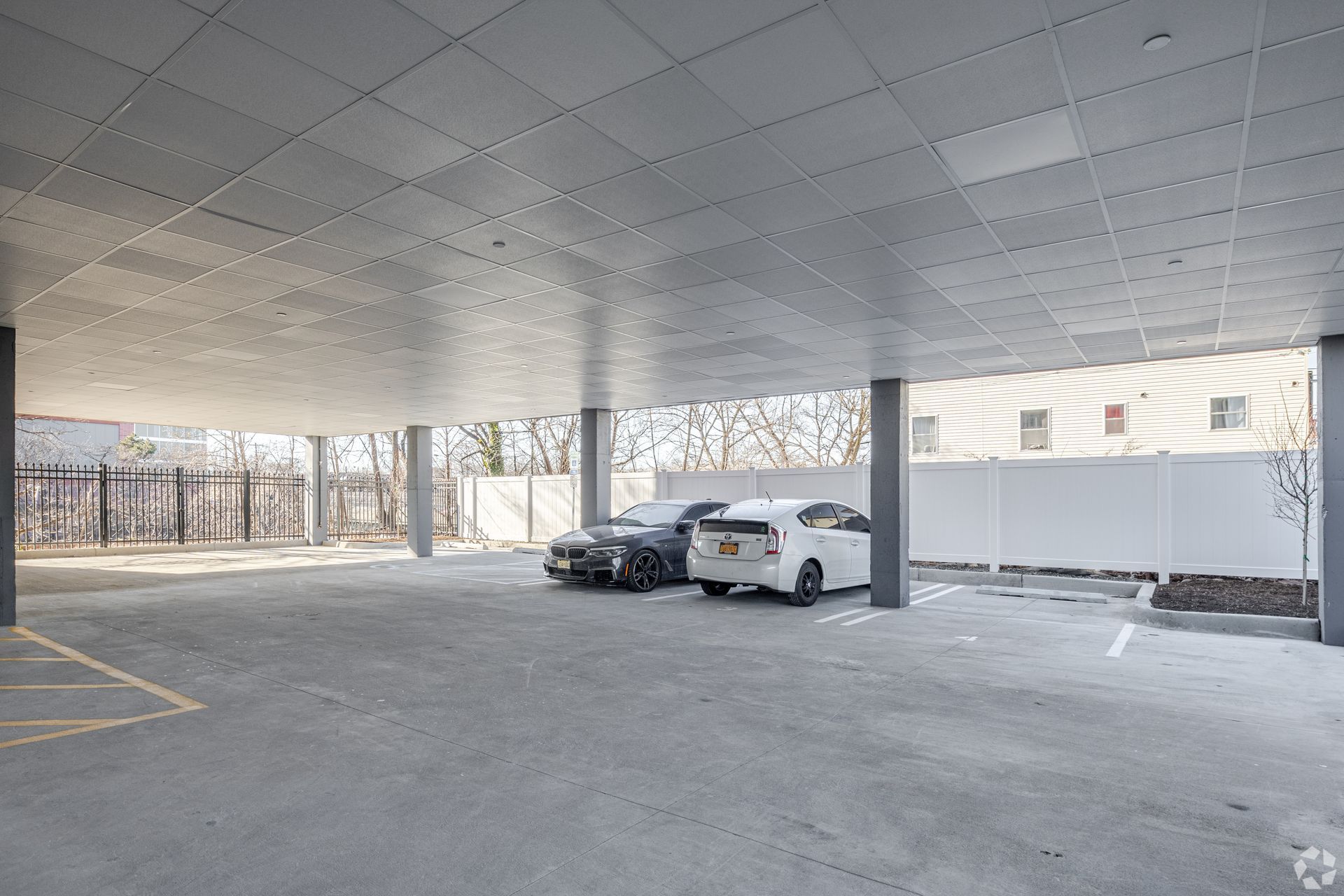 A parking garage with cars parked under a ceiling.- The Unity