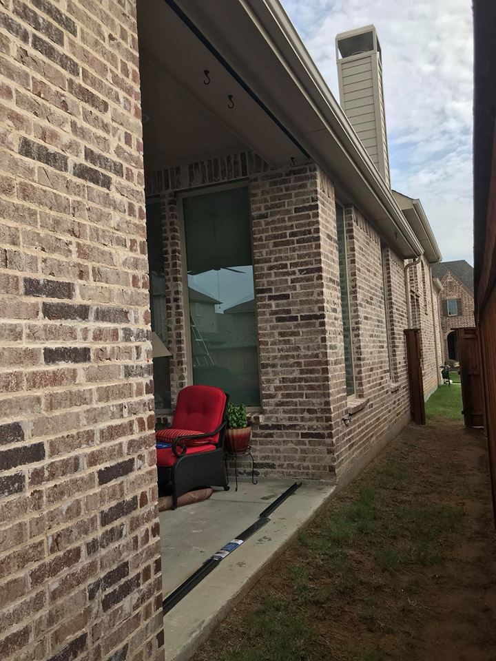 A brick house with a red chair in front of it