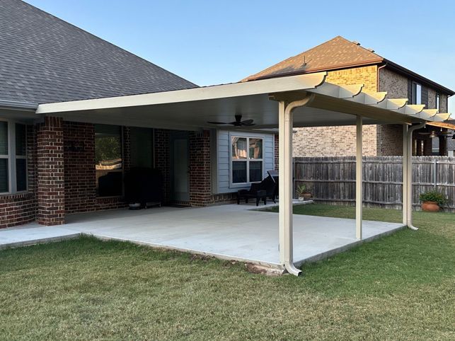 a screened in porch on the side of a brick house .