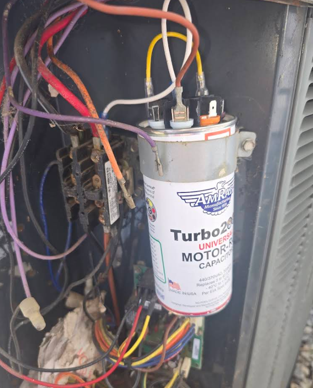 Close-up of a Turbo 200 motor capacitor with tangled multicolored wiring inside electrical equipment.