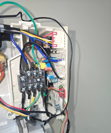 Open electrical panel with exposed wiring, terminals, and circuit components inside a metal box.