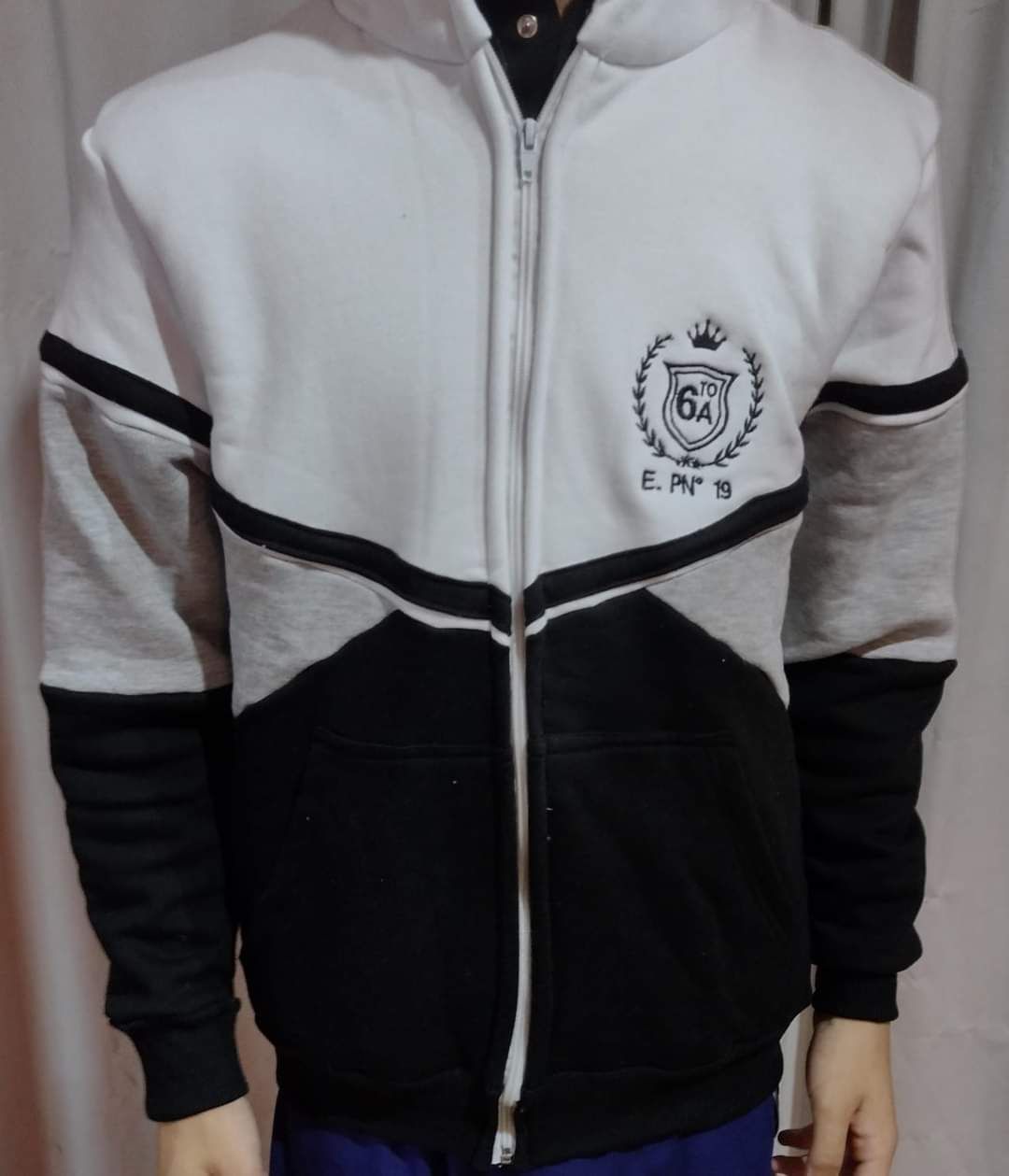 Una persona que lleva una chaqueta blanca y negra con una corona.