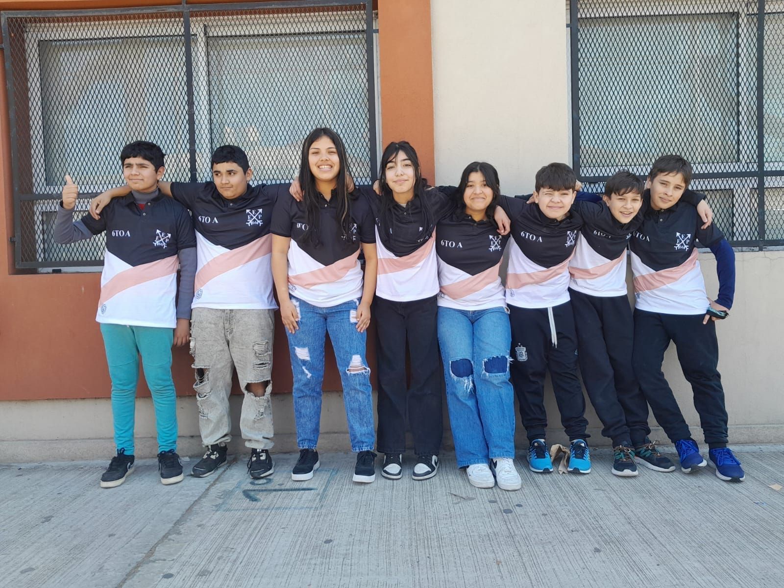 Un grupo de niños posa para una foto frente a un edificio.