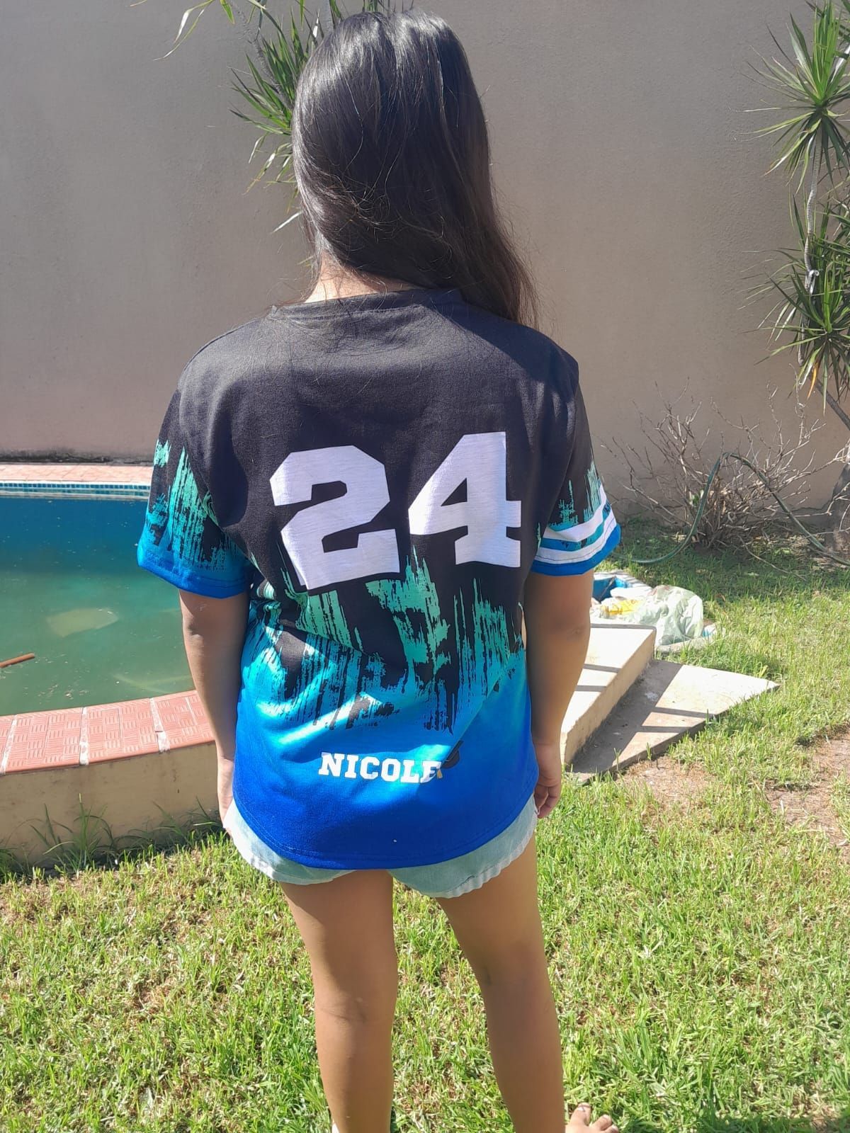 La espalda de una niña que lleva una camiseta con el número 24.