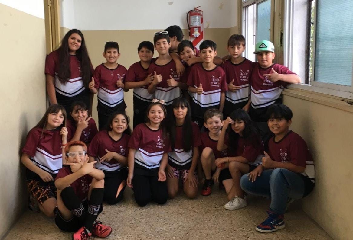 Un grupo de niños posa para una fotografía en una habitación.