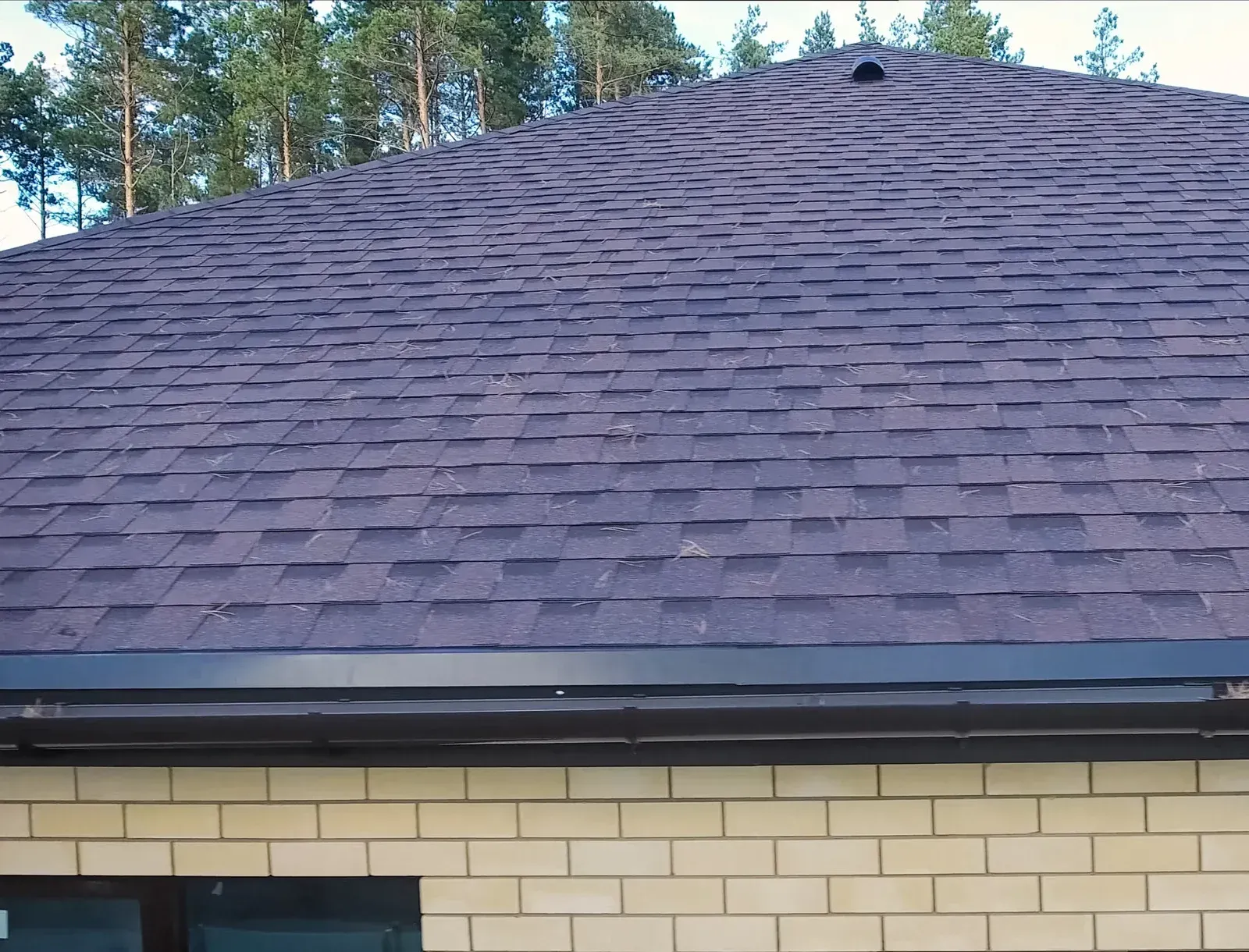 A white bathtub with beige tile walls and floor. A soap dish is mounted on the wall.