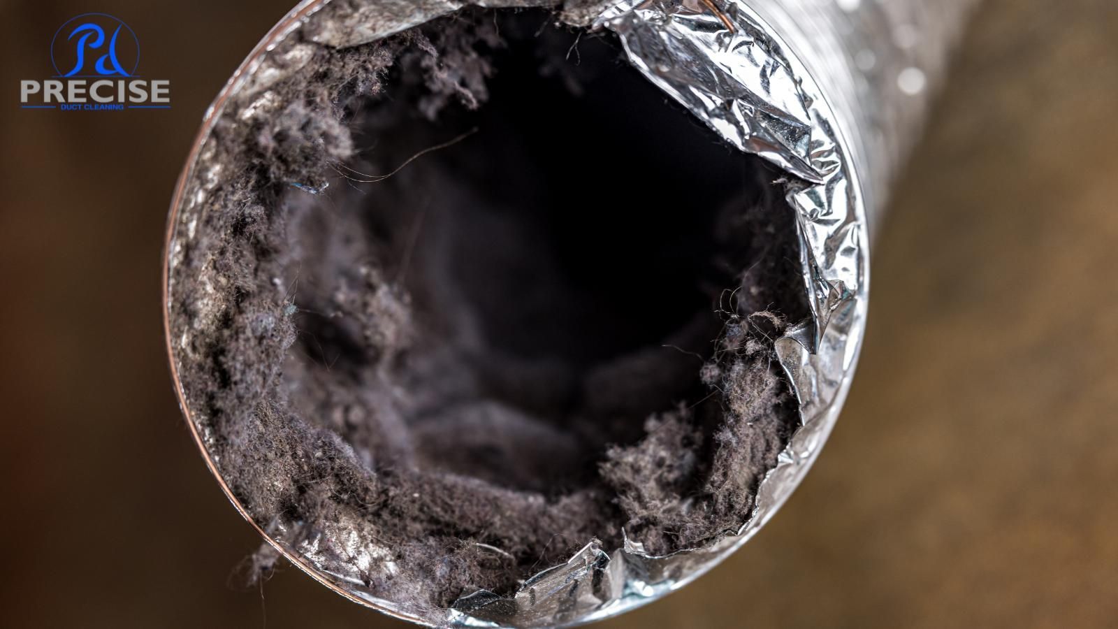 A close up of a dirty duct with smoke coming out of it.