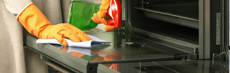 A close up of someone cleaning an oven